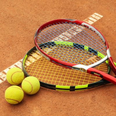 tennis-racquets-with-tennis-balls-on-clay-court.jpg